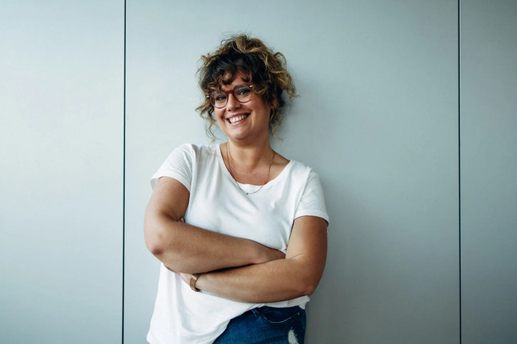 Ein natürliches Lächeln und entspannte Körperhaltung – dieses Bild strahlt Selbstvertrauen und Lebensfreude aus. 